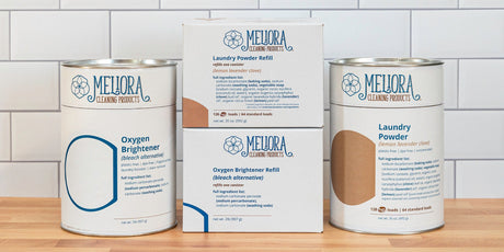 A photo of new all-paper refill boxes next to Meliora Laundry Powder and Oxygen Brightener canisters.