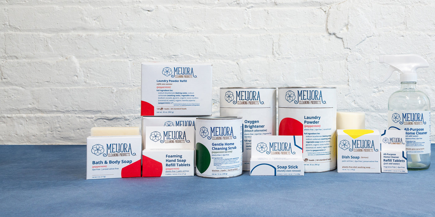 A photo of Meliora Cleaning Products on a blue cloth against a white background.