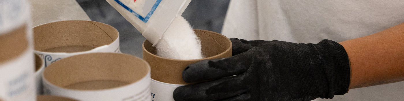 A photo of an employee filling Meliora Laundry Powder canisters at the company's factory in Chicago.