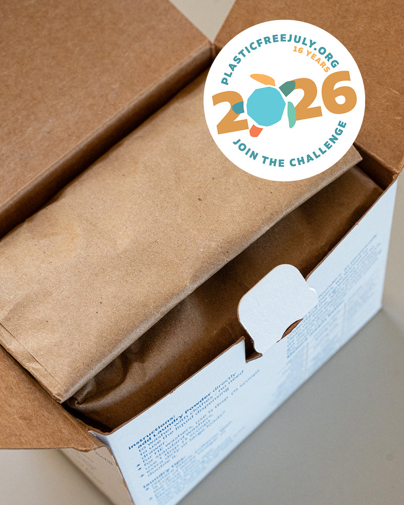 A photo of a plastic-free Laundry Powder Refill box overlaid with the Plastic Free July 2026 logo.