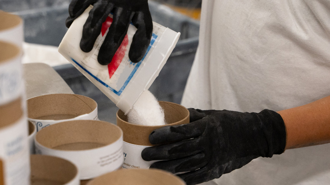 A Meliora employee filling Laundry Powder canisters in the production facility.