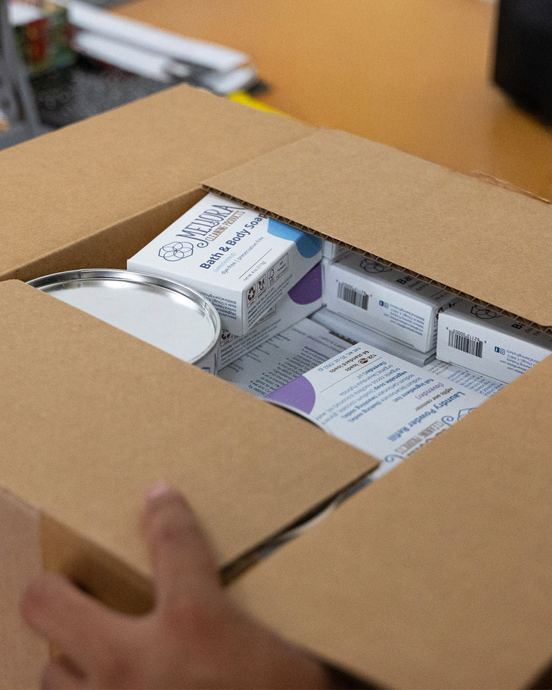 A photo of a Meliora Cleaning Products team member packaging a shipment of cleaning products.